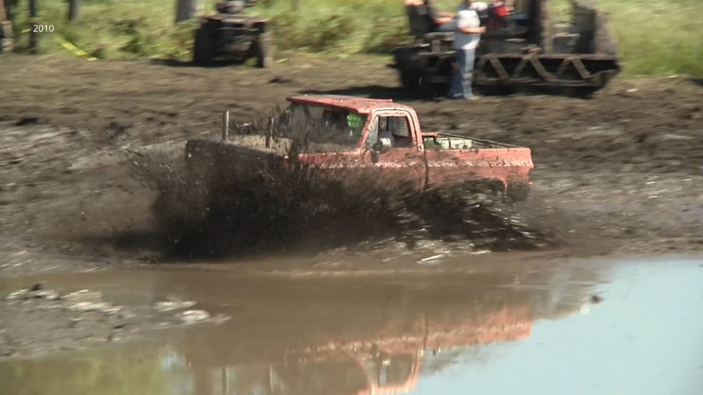 A truck drives through a mud bog