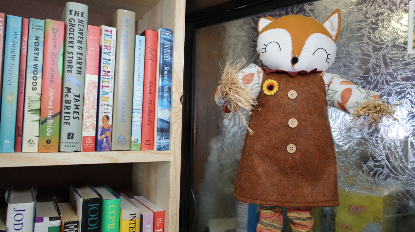 A fox figurine next to bookshelves