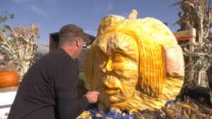 Clayton Johnson carves a face into a giant pumpkin