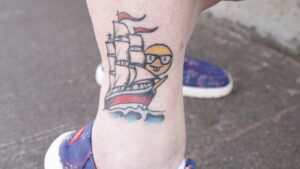 Lauren Olson's "boat nerd" tattoo shows a ship and an emoji with glasses