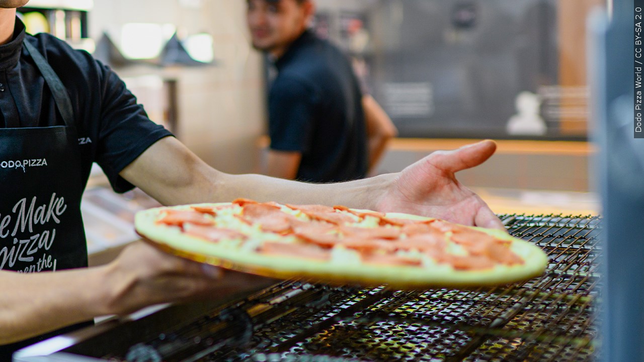 A pizza being put into an oven