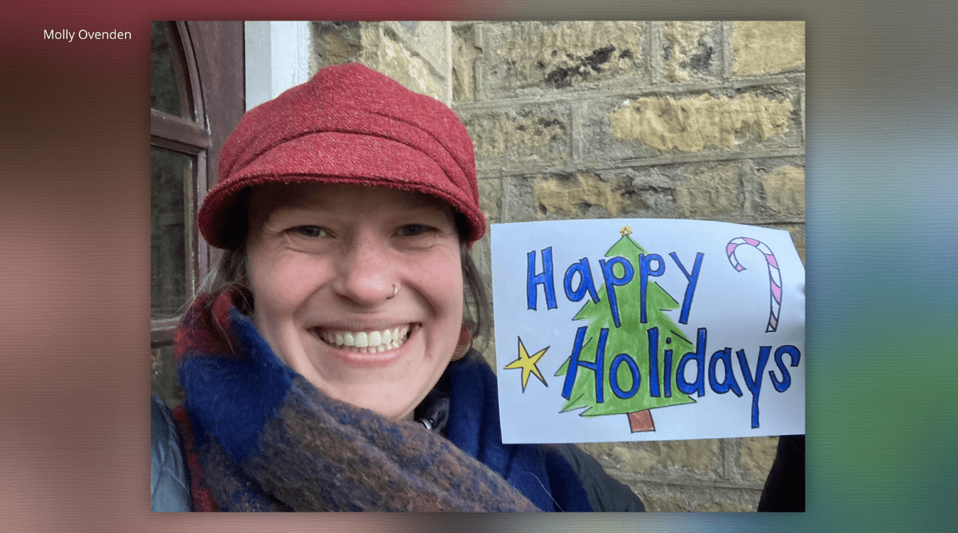 Molly Ovenden with a "Happy Holidays" sign