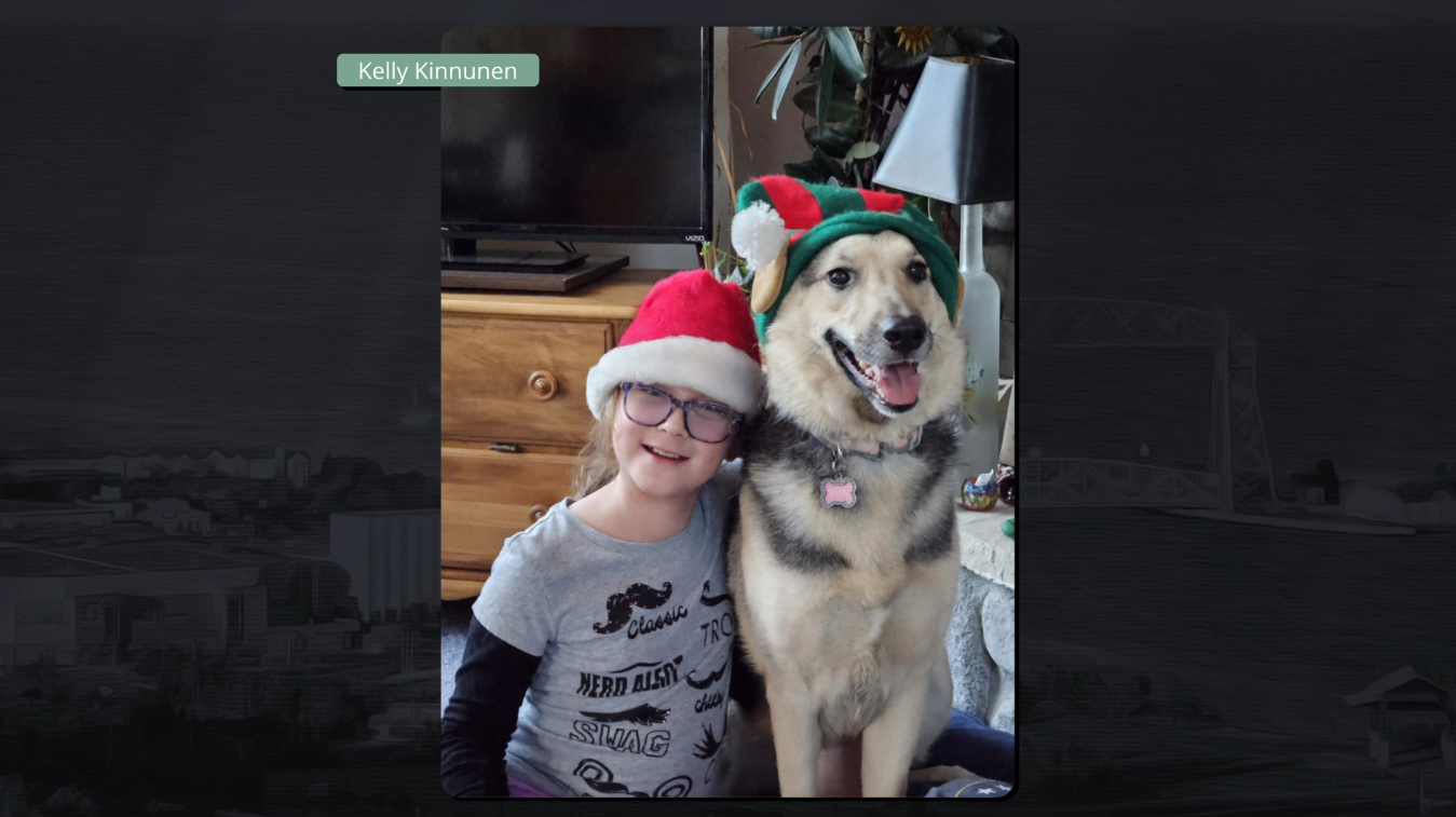 A girl and a dog wear festive hats